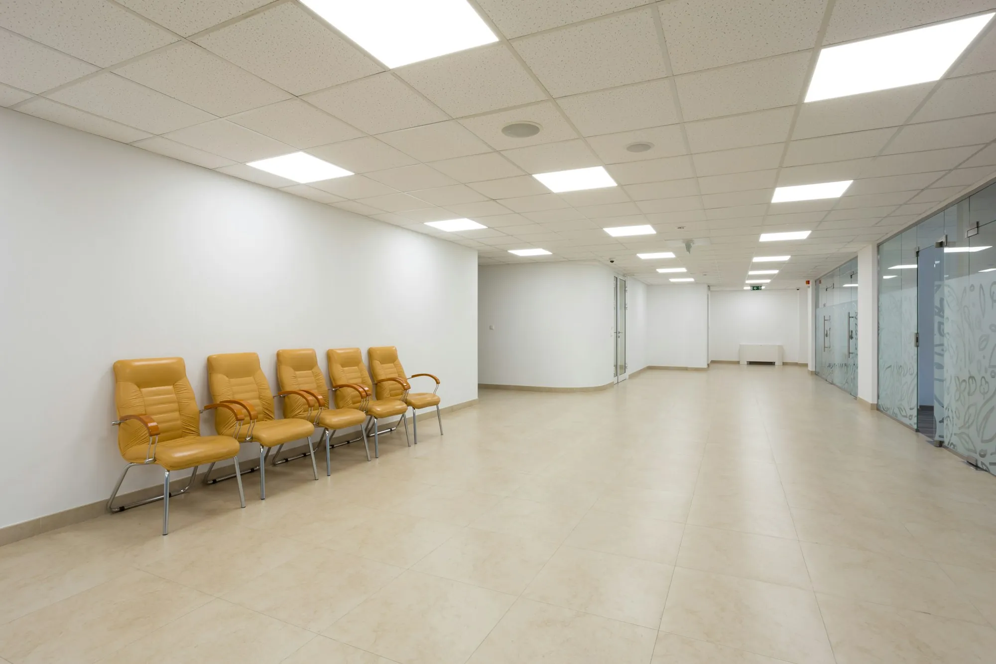 Empty waiting area with yellow chairs and light floors