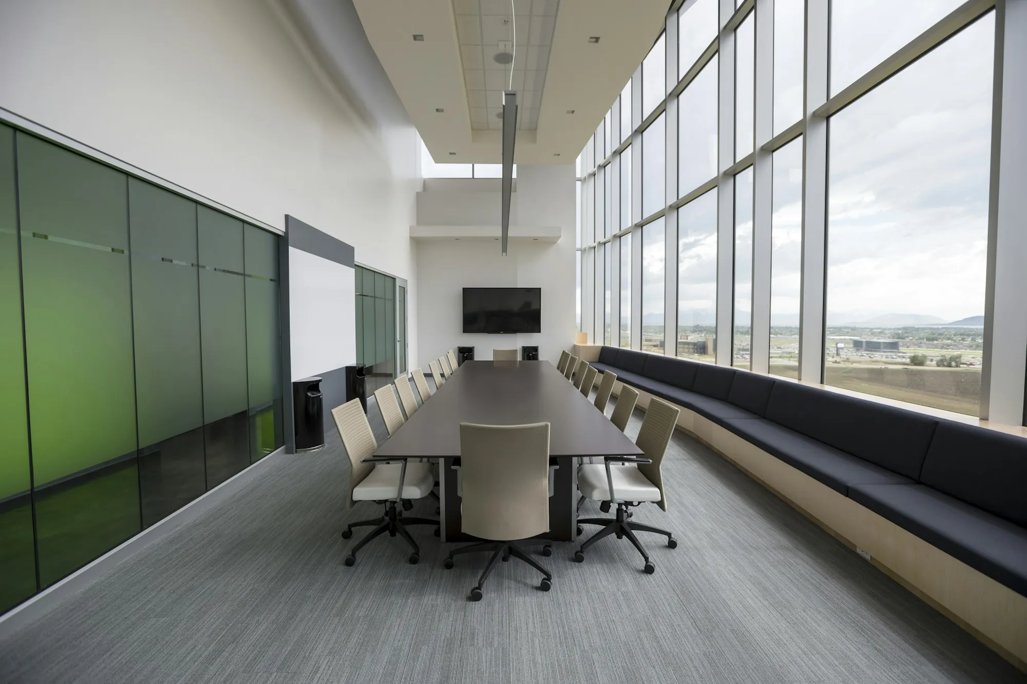 Long boardroom table beside floor-to-ceiling windows