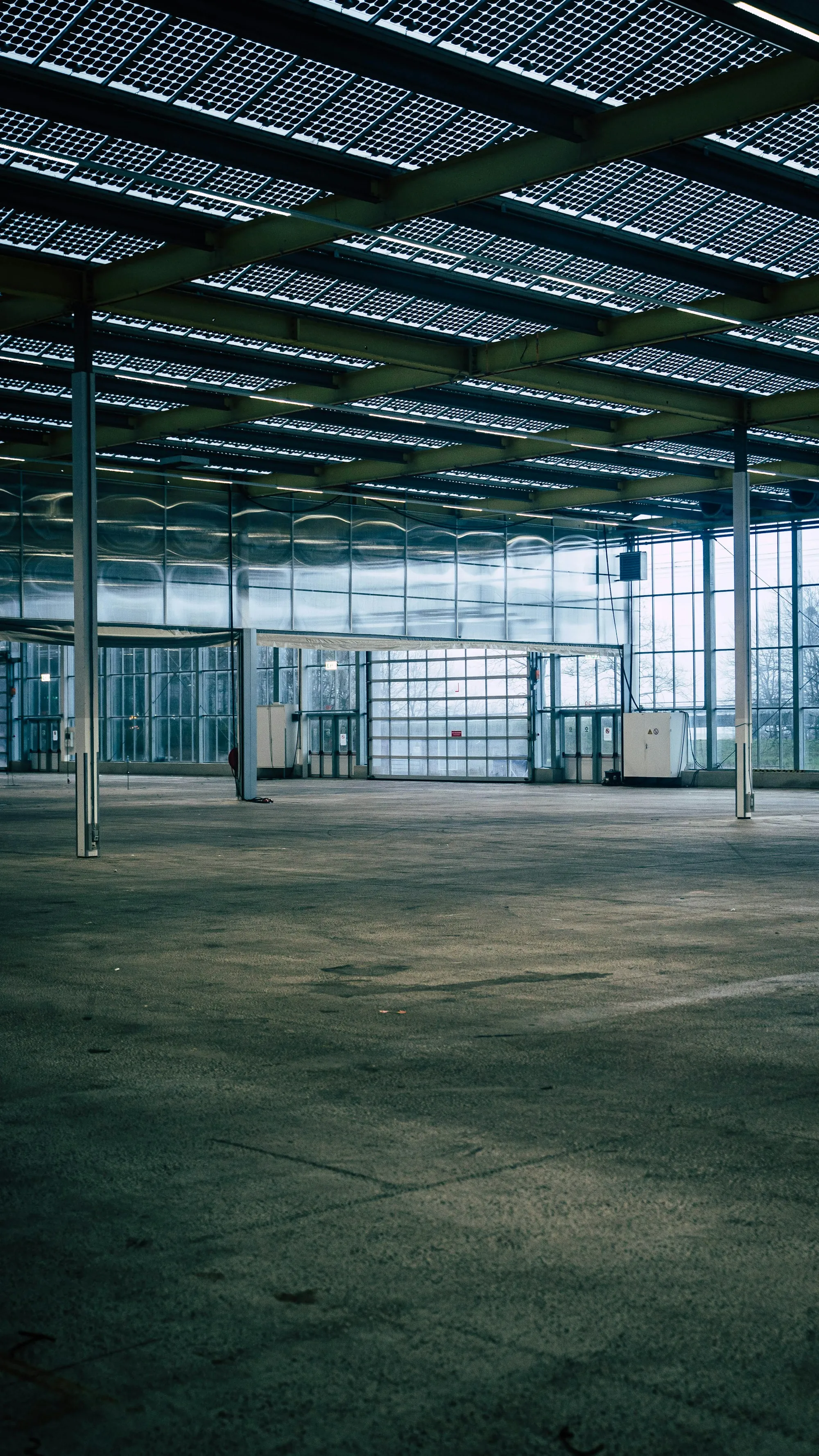 Large glass-walled hall with an open concrete floor